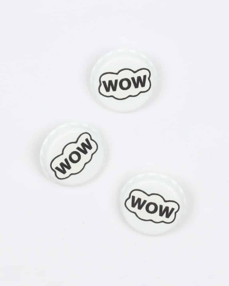 Hvid kapsel med teksten, wow - 22 mm -